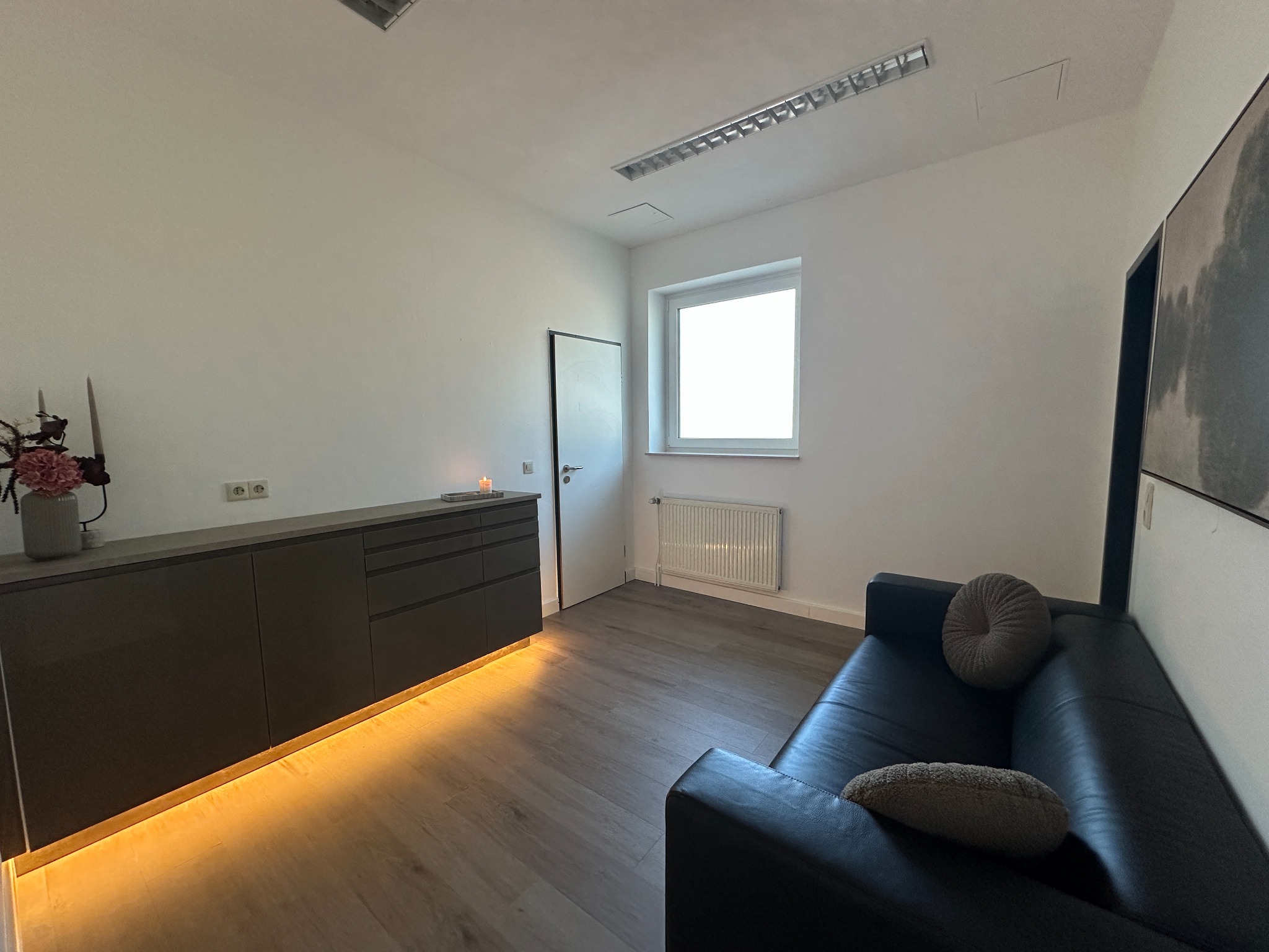 Zweite Ansicht der Lounge mit Fenster und Sideboard
